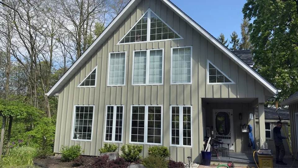 Gabled house with tall windows, triangular glazing and vertical siding
