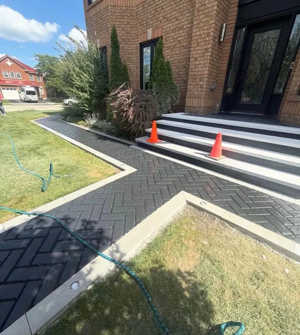 Herringbone paver walkway meeting broad light-edged entrance steps
